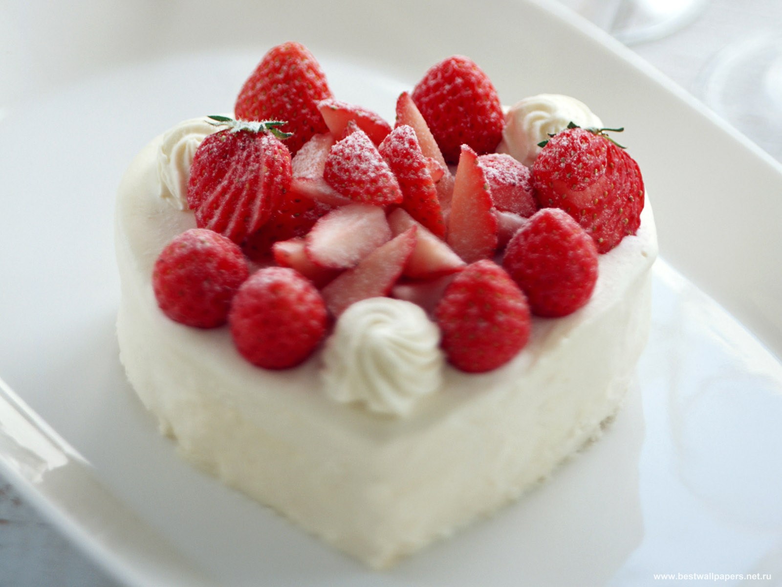 пирожное в форме сердечка с красными ягодами